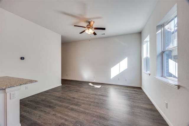 unfurnished living room featuring dark hardwood / wood-style flooring and ceiling fan