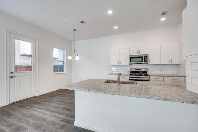 kitchen with light stone countertops, appliances with stainless steel finishes, sink, and white cabinets