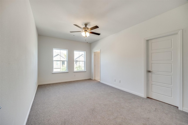 unfurnished room with light colored carpet and ceiling fan