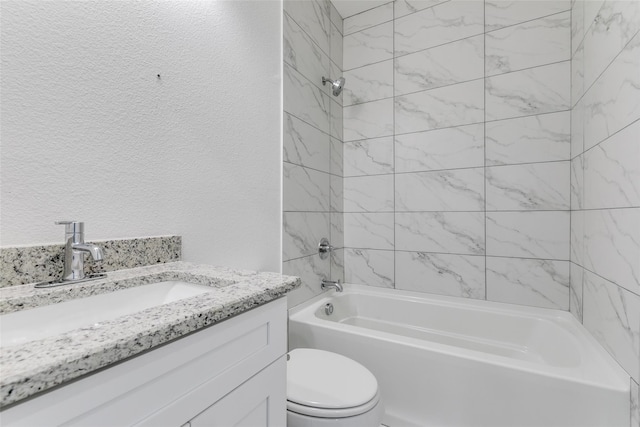 full bathroom featuring vanity, tiled shower / bath, and toilet