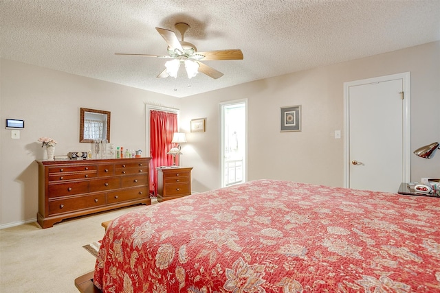 carpeted bedroom featuring ceiling fan and a textured ceiling