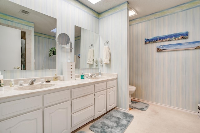 bathroom featuring vanity, toilet, and a textured ceiling