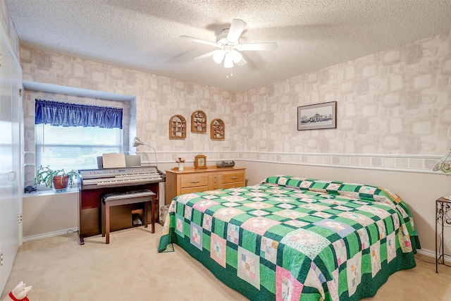 bedroom with ceiling fan, light carpet, and a textured ceiling