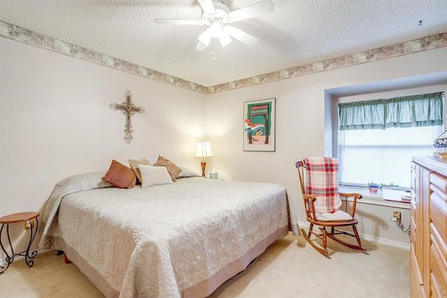 bedroom featuring a textured ceiling, ceiling fan, and light carpet