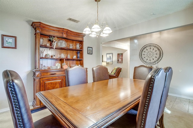 tiled dining area featuring a notable chandelier and a textured ceiling