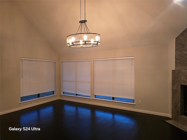 unfurnished living room with lofted ceiling, hardwood / wood-style floors, and a notable chandelier