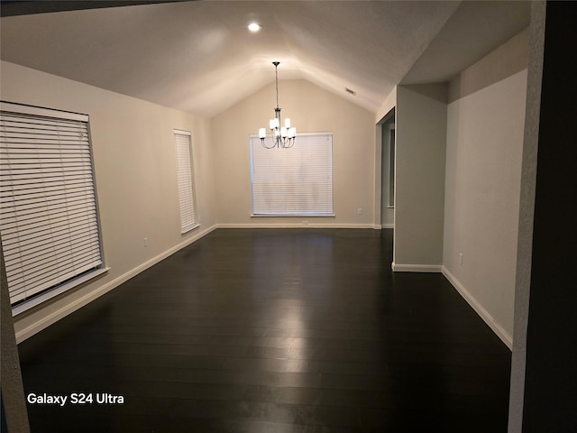 spare room with vaulted ceiling, dark hardwood / wood-style floors, and a chandelier