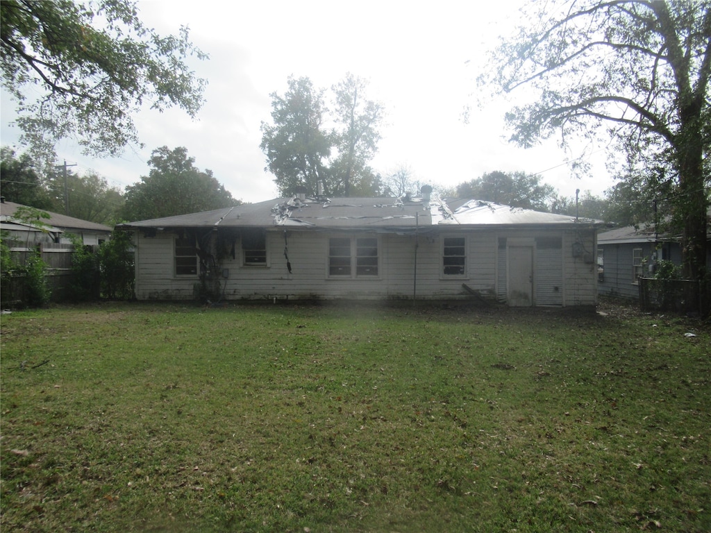 rear view of property with a lawn