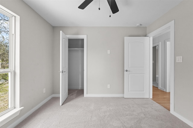 unfurnished bedroom with ceiling fan, light carpet, and a closet