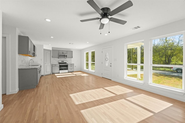 906 Benton St, Bonham, TX 75418 - unfurnished living room with a sink, light wood-type flooring, recessed lighting, a ceiling fan, and baseboards