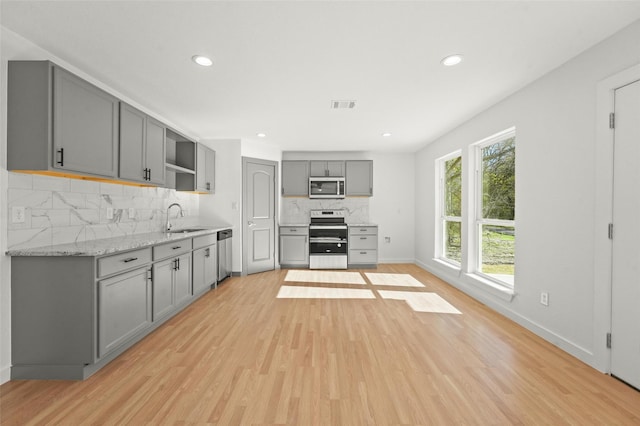 906 Benton St, Bonham, TX 75418 - kitchen featuring stainless steel appliances, gray cabinets, light wood-style flooring, a sink, and recessed lighting