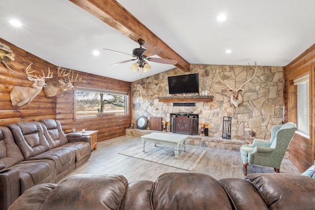 living room with a fireplace, lofted ceiling with beams, log walls, ceiling fan, and light hardwood / wood-style floors