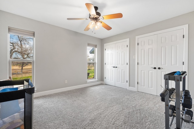 bedroom featuring multiple closets, carpet floors, and ceiling fan