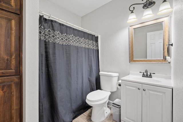 bathroom with vanity, curtained shower, and toilet