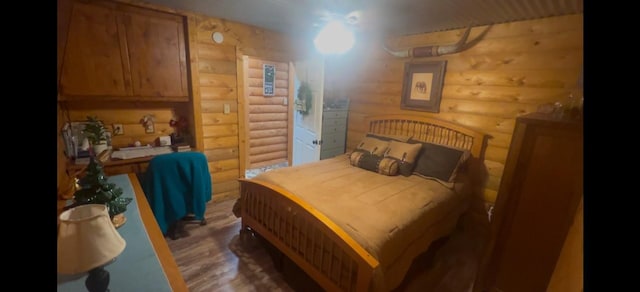 bedroom featuring dark hardwood / wood-style floors and log walls