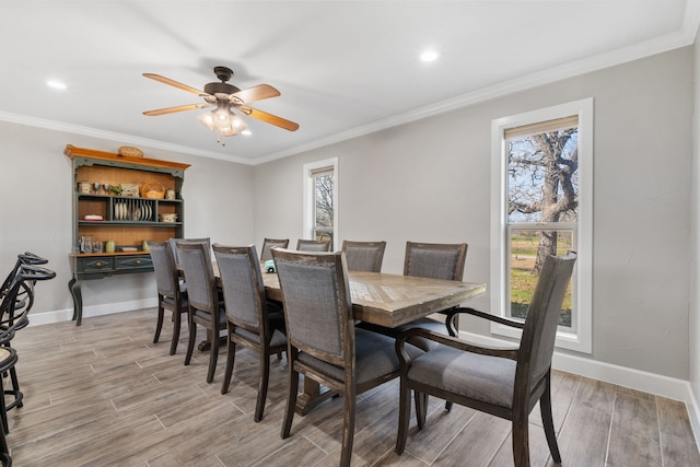 dining space featuring crown molding, a healthy amount of sunlight, and light hardwood / wood-style floors