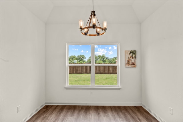 unfurnished dining area featuring a notable chandelier, lofted ceiling, and hardwood / wood-style flooring