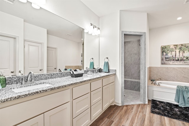 bathroom featuring hardwood / wood-style flooring, vanity, and shower with separate bathtub