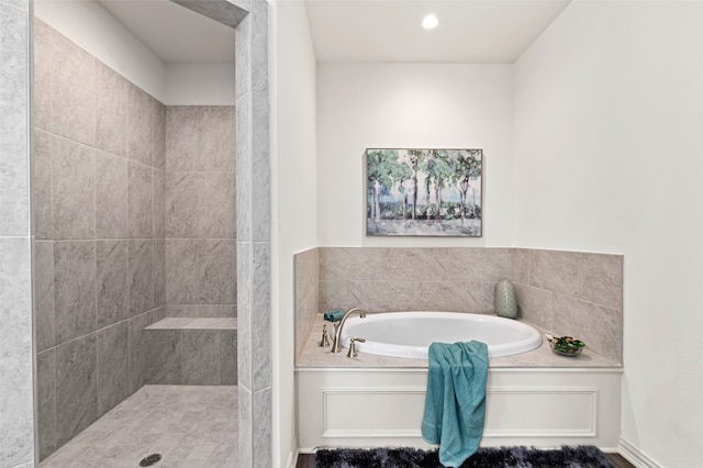 bathroom featuring separate shower and tub