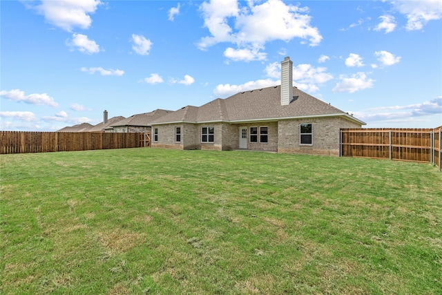 rear view of property featuring a yard