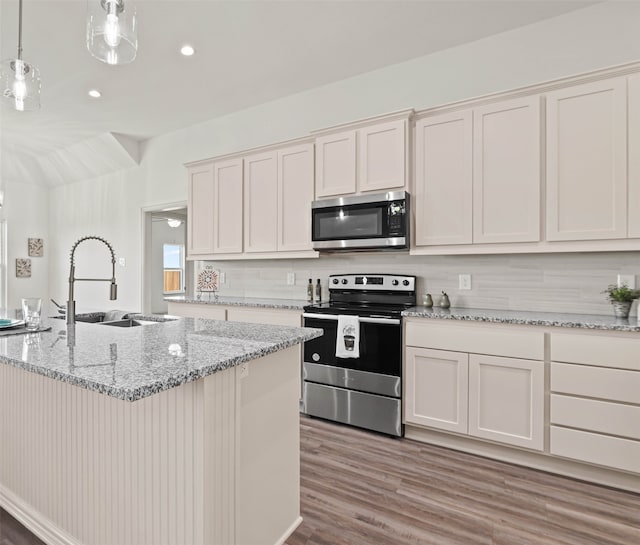 kitchen featuring pendant lighting, white cabinets, sink, light hardwood / wood-style floors, and stainless steel appliances