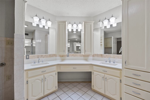 bathroom featuring tile patterned flooring, vanity, an enclosed shower, and a textured ceiling