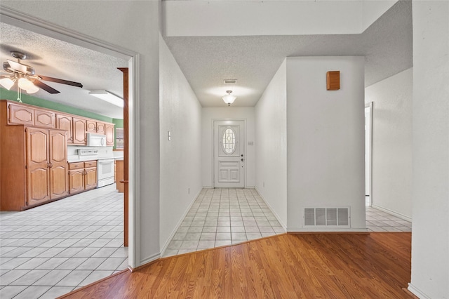 entrance foyer featuring light tile patterned floors, a textured ceiling, and ceiling fan