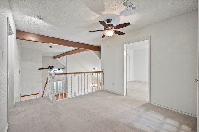 carpeted spare room featuring vaulted ceiling with beams, ceiling fan, and a textured ceiling