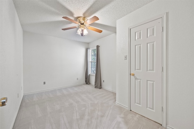 carpeted empty room with ceiling fan and a textured ceiling