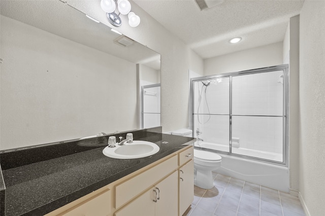 full bathroom with a textured ceiling, vanity, enclosed tub / shower combo, tile patterned flooring, and toilet