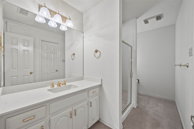 bathroom featuring vanity, a textured ceiling, and walk in shower