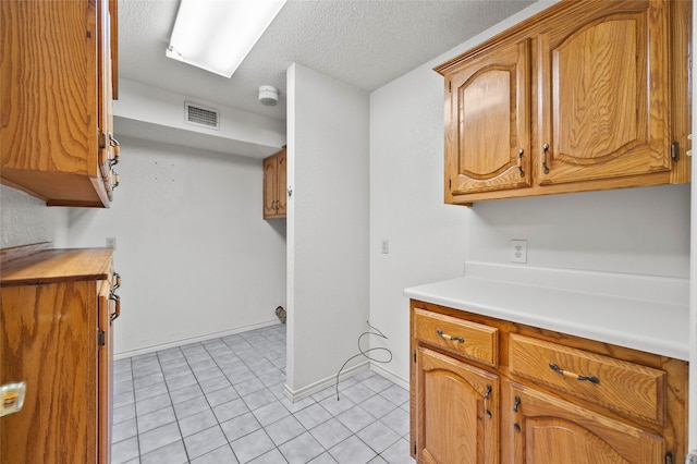 kitchen featuring light tile patterned flooring and a textured ceiling