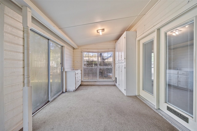 unfurnished sunroom featuring lofted ceiling