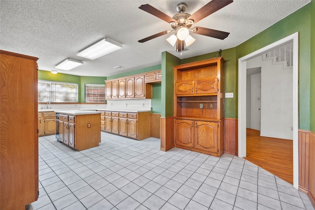 kitchen featuring a textured ceiling, a center island, light hardwood / wood-style floors, and ceiling fan