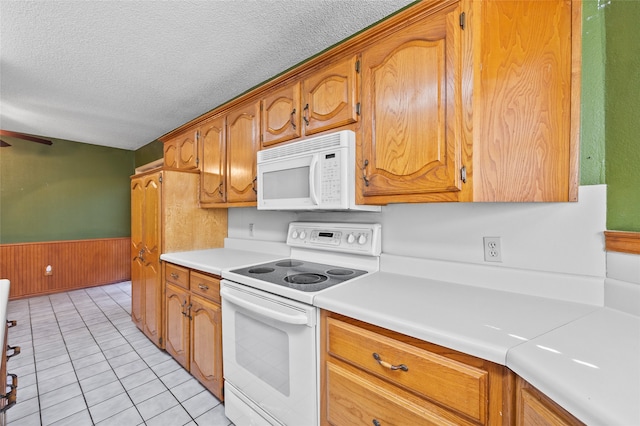 kitchen featuring a textured ceiling, ceiling fan, light tile patterned floors, and white appliances