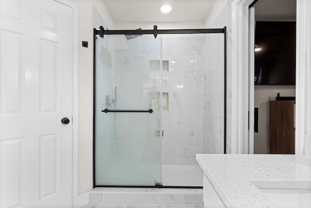 bathroom featuring vanity and a shower with shower door