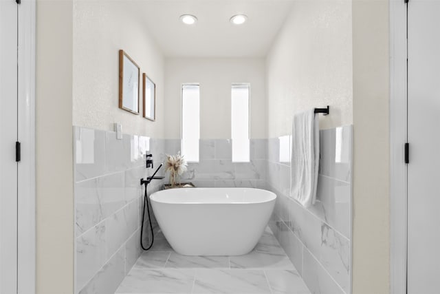 bathroom with a bath and tile walls