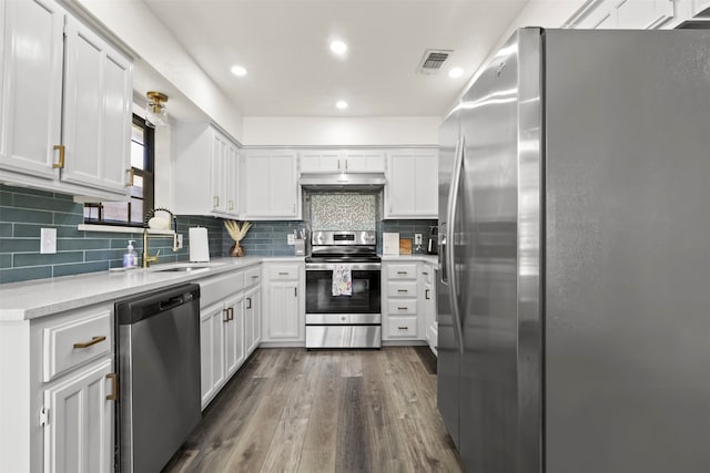 kitchen featuring white cabinetry, sink, dark wood-type flooring, stainless steel appliances, and extractor fan