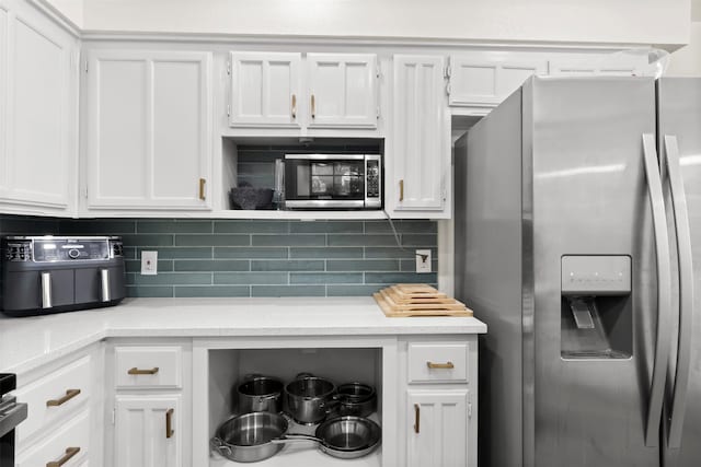 kitchen featuring backsplash, stainless steel appliances, and white cabinetry