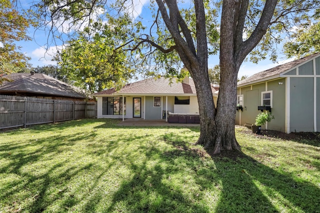 rear view of property featuring a patio area and a lawn