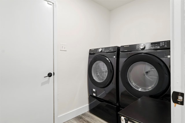 laundry room with washer and clothes dryer and light wood-type flooring