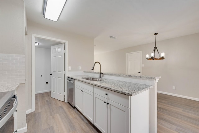 kitchen with dishwasher, sink, light stone counters, white cabinetry, and a chandelier