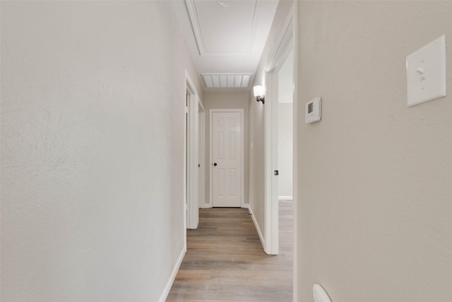 hall with hardwood / wood-style floors and ornamental molding