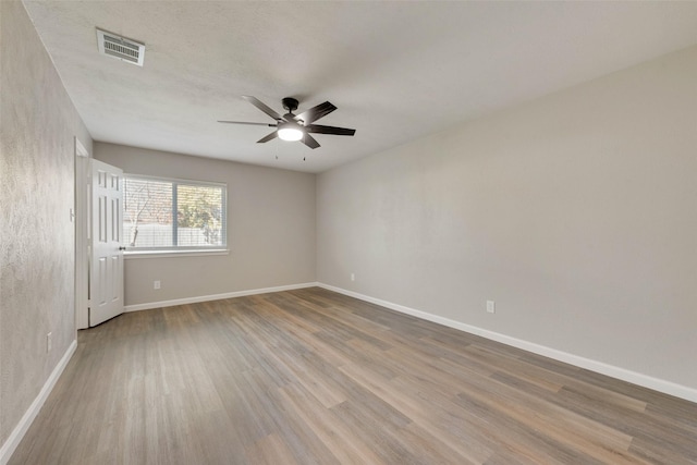 empty room featuring ceiling fan and light wood-type flooring