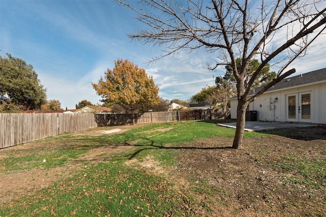 view of yard with central AC and french doors