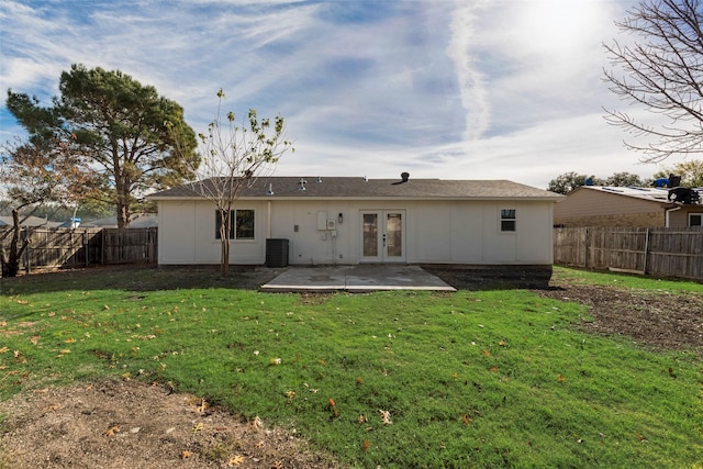 rear view of property featuring central AC, a yard, a patio, and french doors