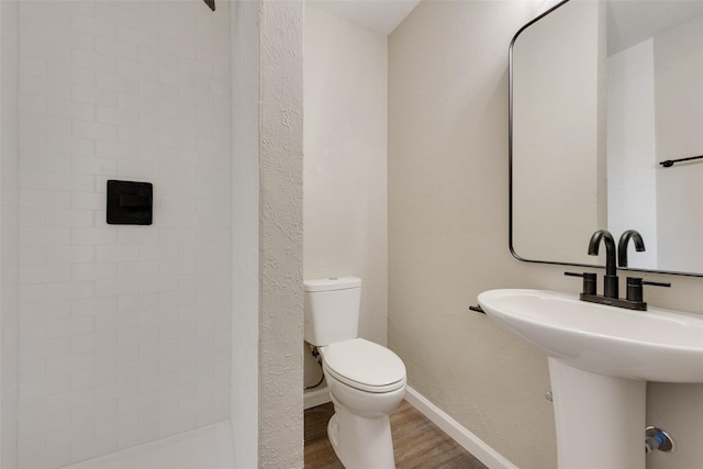 bathroom with wood-type flooring, toilet, and sink