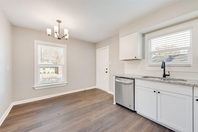 kitchen featuring light wood-type flooring, light stone counters, stainless steel dishwasher, sink, and white cabinetry