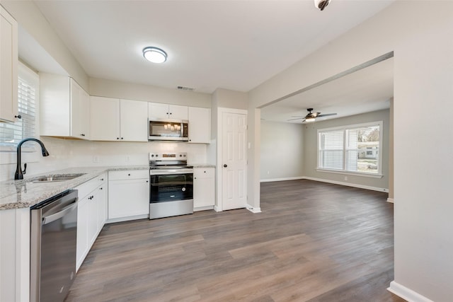 kitchen featuring appliances with stainless steel finishes, ceiling fan, sink, hardwood / wood-style flooring, and white cabinetry