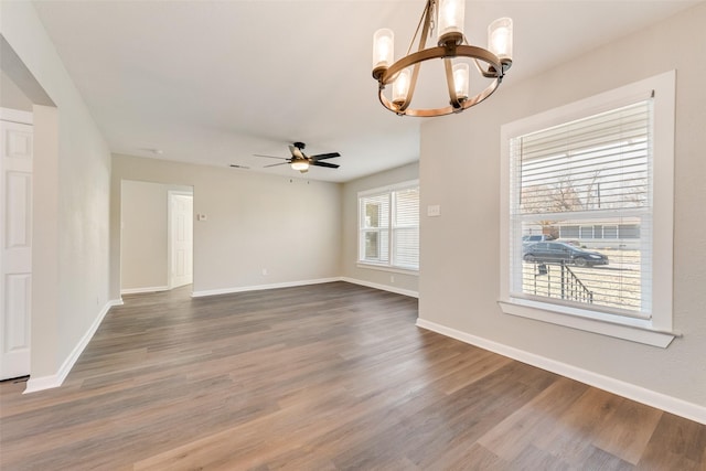 unfurnished room featuring ceiling fan with notable chandelier and hardwood / wood-style flooring